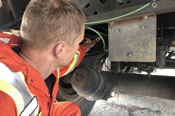 Man inspecting vehicle's suspension system